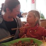 Meine Tochter Romy und meine Frau Doris essen zusammen mit Stäbchen ein rohveganes asiatisches Gericht im Restaurant Mei Wok in Köln.